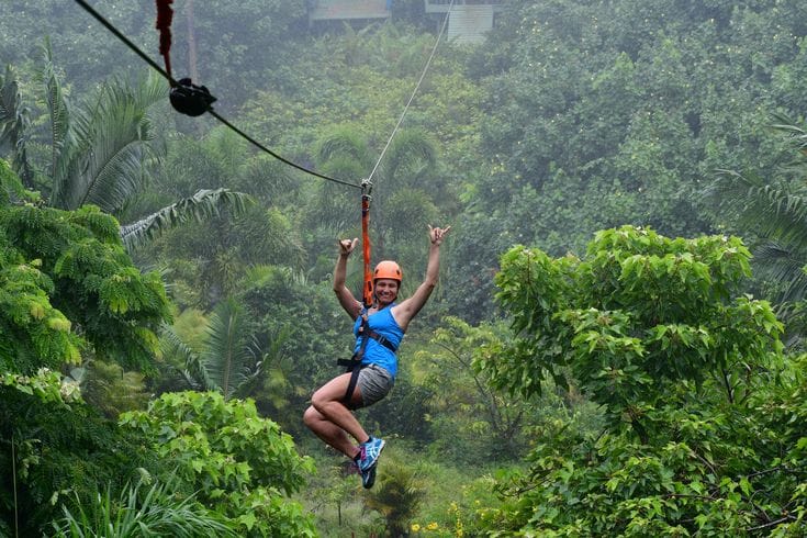 Da Lat Ziplining – Adventurer ziplining over pine forest in Da Lat, Vietnam.